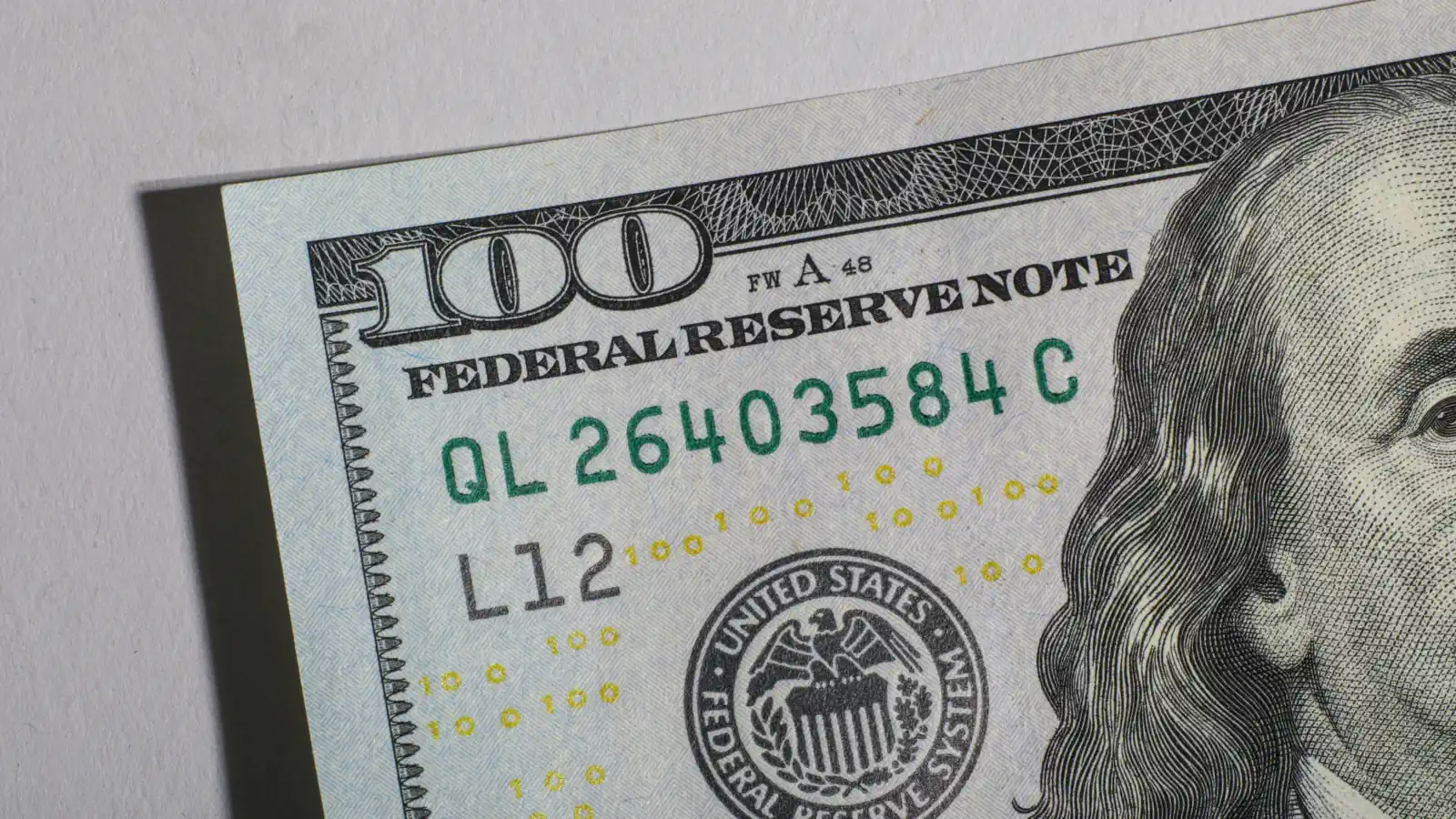 Close-up of a US one hundred dollar bill showing the words Federal Reserve Note and the Federal Reserve seal
