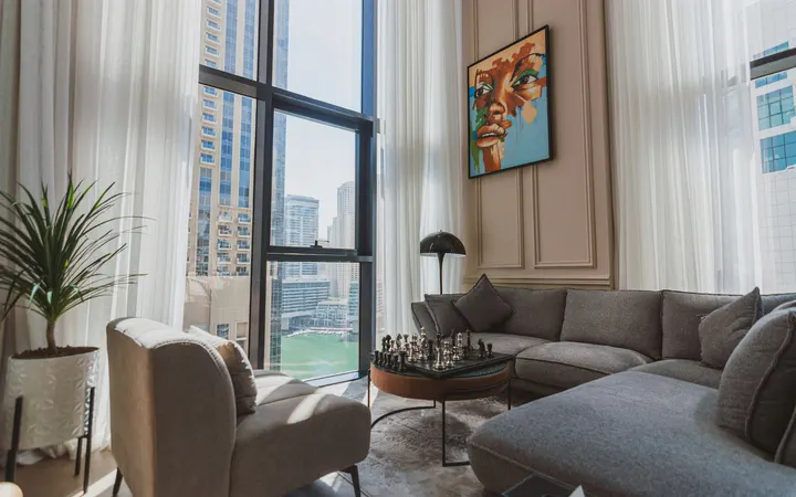 Bright Dubai Marina apartment living room with floor-to-ceiling windows and a view of the marina