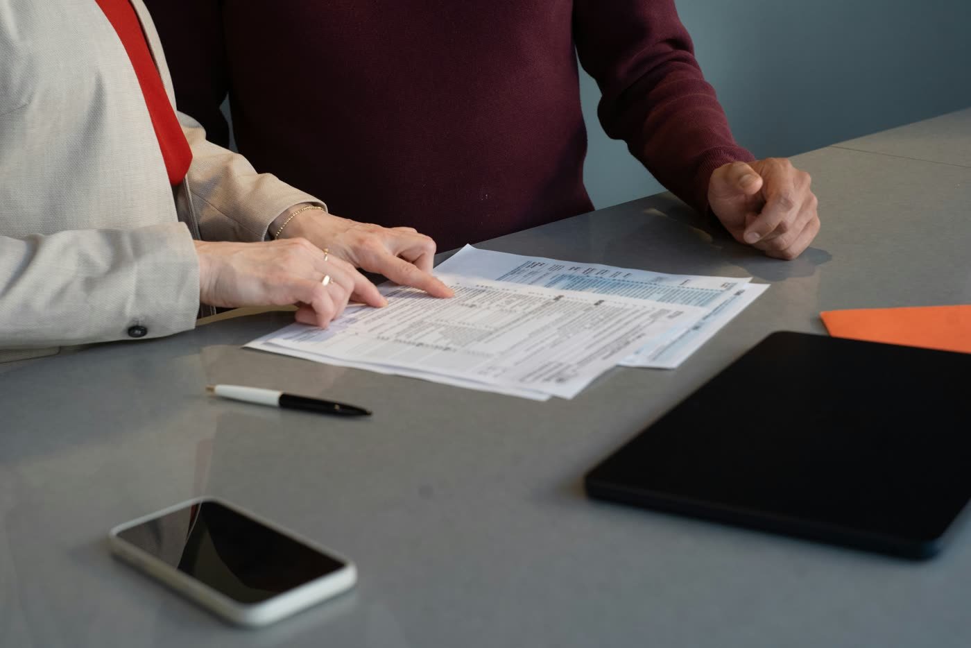 Advisor reviewing mortgage paperwork and a house model on a desk