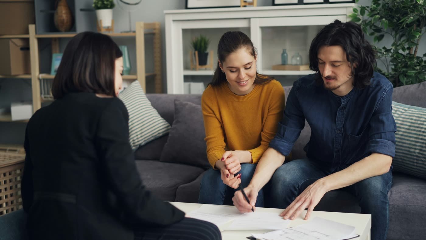 Couple signing mortgage documents with their advisor