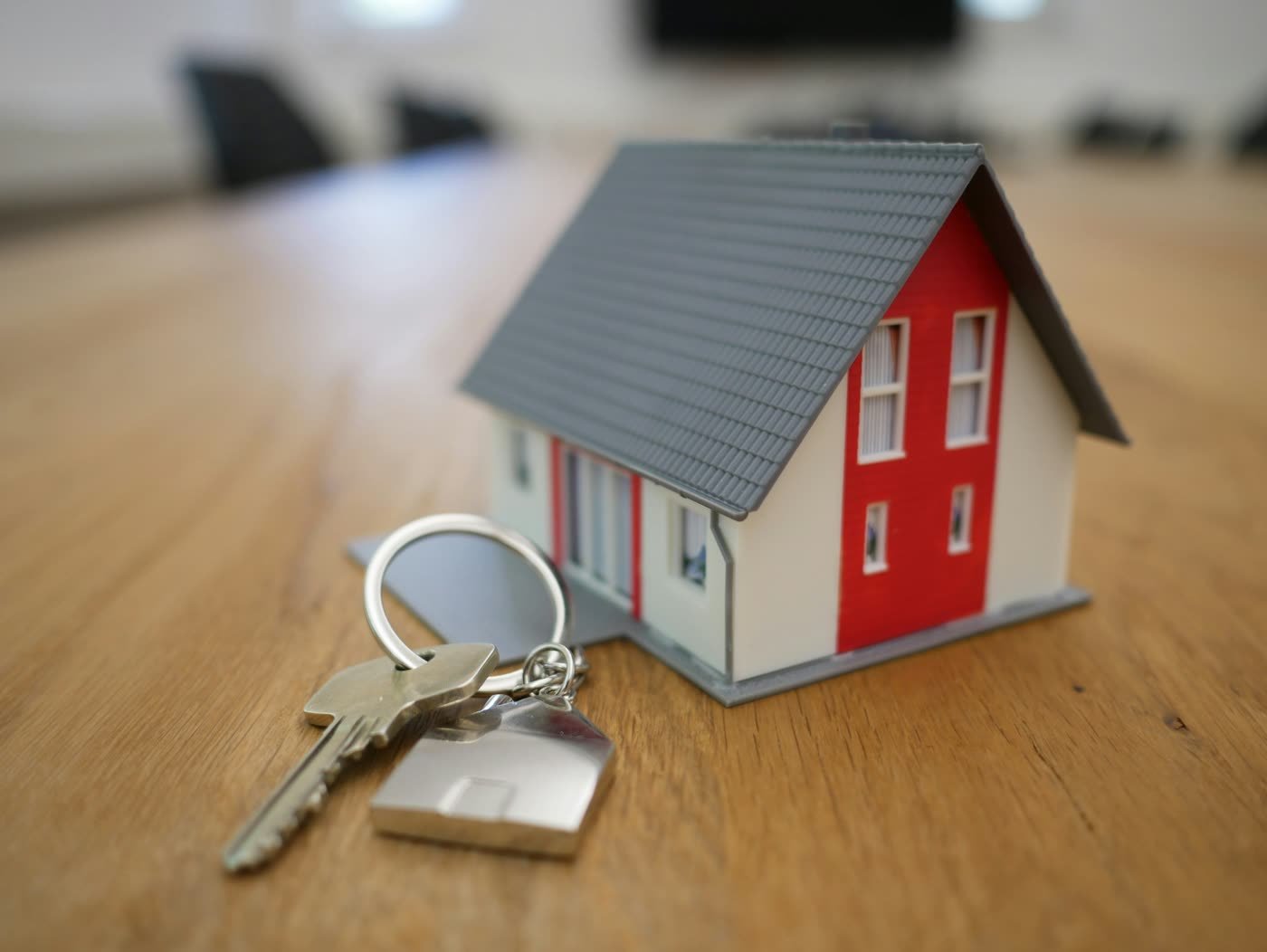 House-shaped keychain with keys on a table after mortgage completion